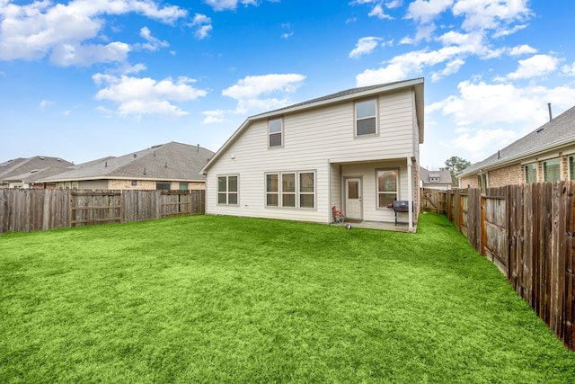 rear view of property with a yard and a patio area