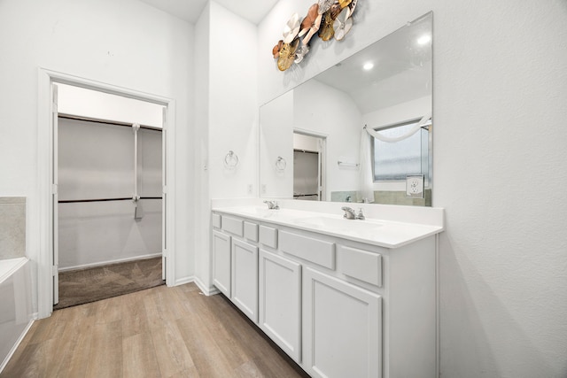 bathroom with lofted ceiling, vanity, and wood-type flooring