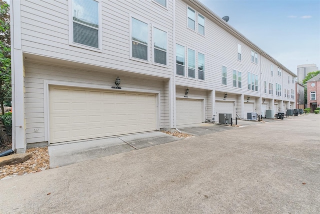 view of side of property featuring cooling unit and an attached garage