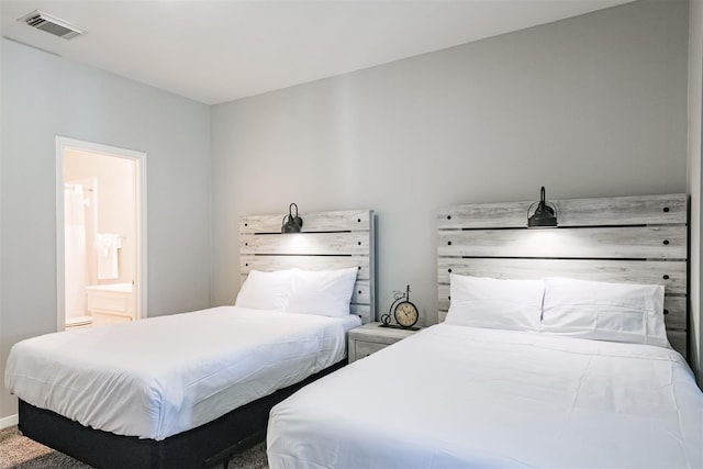 bedroom with ensuite bath and visible vents