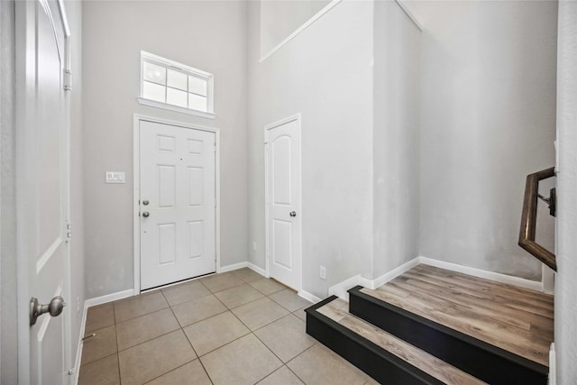 tiled foyer entrance with a towering ceiling