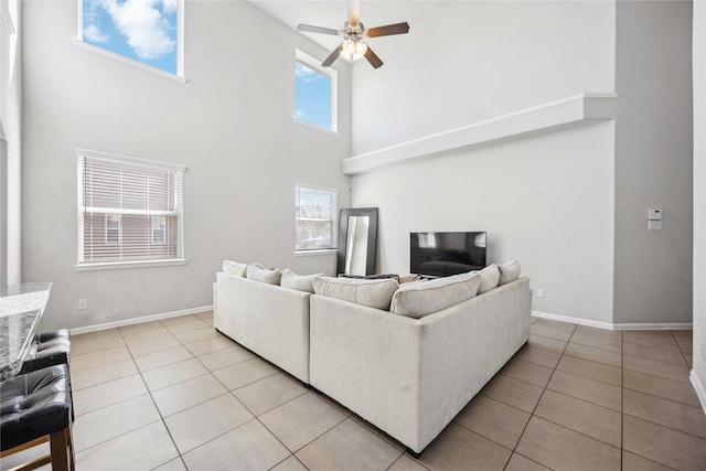 tiled living room featuring a towering ceiling and ceiling fan