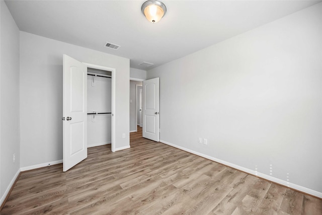 unfurnished bedroom featuring light hardwood / wood-style floors and a closet