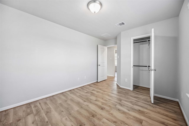 unfurnished bedroom with light hardwood / wood-style flooring and a closet