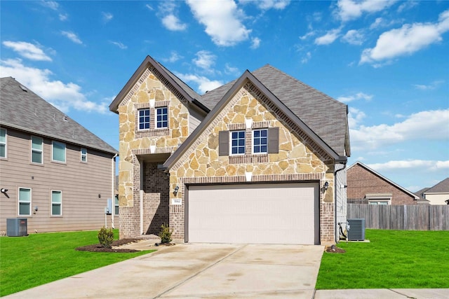 view of front of property with a garage, central AC, and a front yard