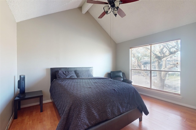 bedroom featuring lofted ceiling with beams, ceiling fan, baseboards, and wood finished floors