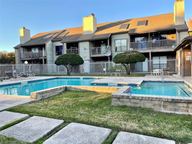 pool featuring a yard and fence