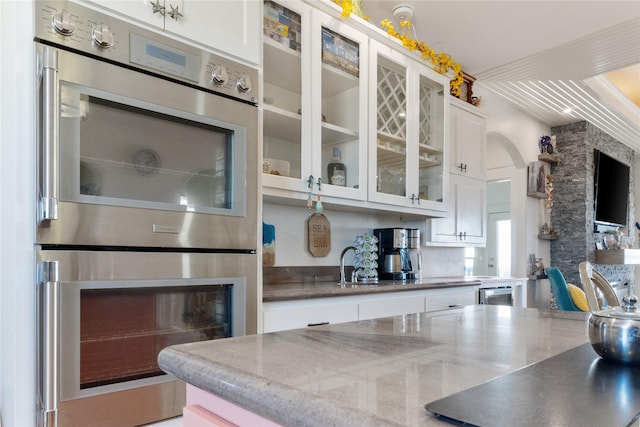 kitchen with stainless steel double oven and white cabinets