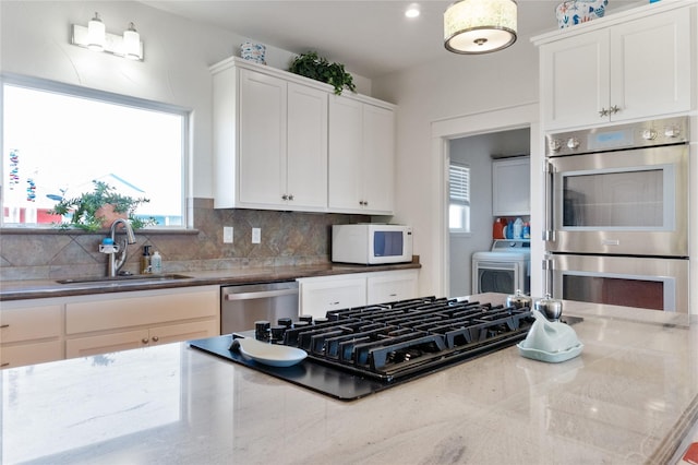 kitchen featuring light stone countertops, white cabinetry, appliances with stainless steel finishes, and sink