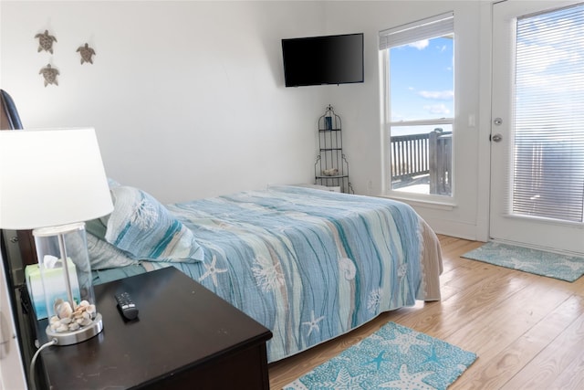 bedroom with french doors, wood-type flooring, and access to outside