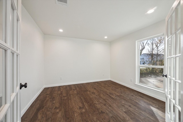 spare room featuring dark hardwood / wood-style flooring and french doors