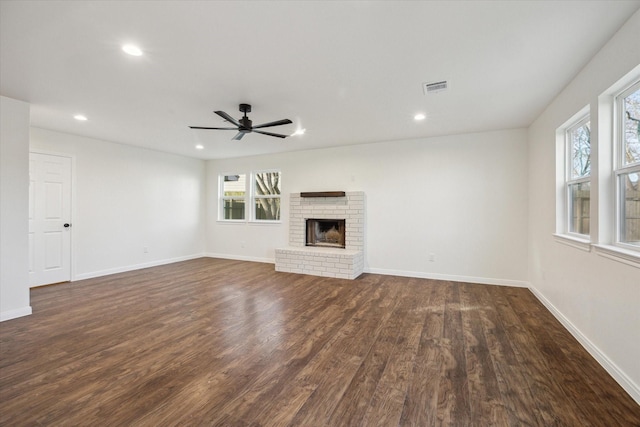 unfurnished living room featuring ceiling fan, dark hardwood / wood-style floors, and a fireplace