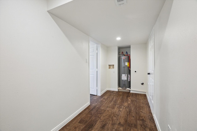 hallway with water heater and dark wood-type flooring