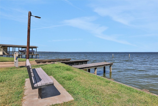 dock area with a water view and a lawn