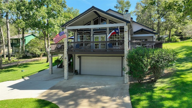 coastal inspired home with a wooden deck, a garage, a front lawn, and french doors