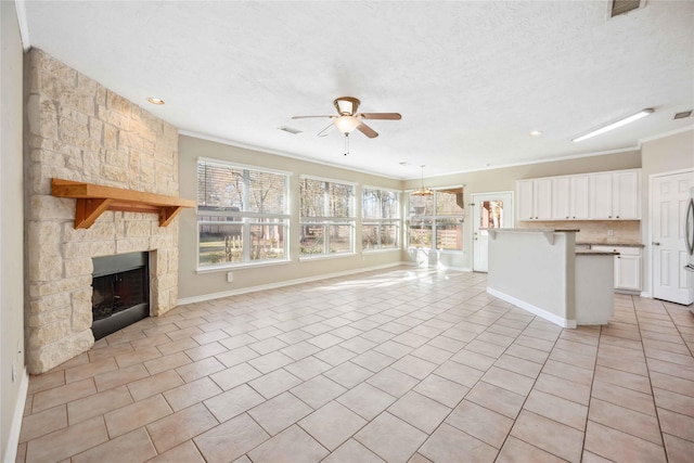 unfurnished living room featuring a textured ceiling, a fireplace, ceiling fan, and light tile patterned flooring