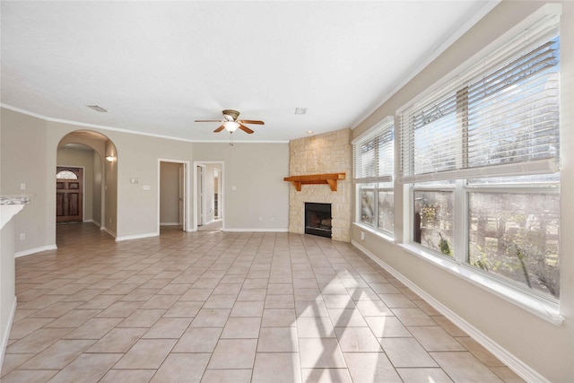 unfurnished living room featuring light tile patterned flooring, ornamental molding, ceiling fan, and a fireplace