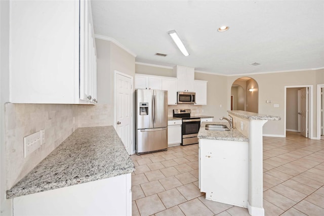 kitchen featuring sink, white cabinetry, stainless steel appliances, light stone countertops, and an island with sink