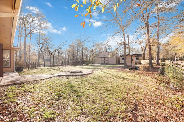 view of yard with a shed and a fire pit