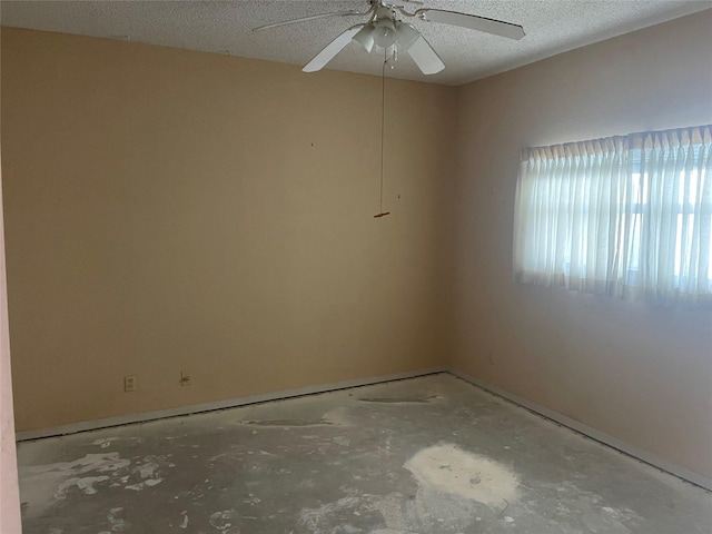 unfurnished room with a textured ceiling, concrete floors, and ceiling fan