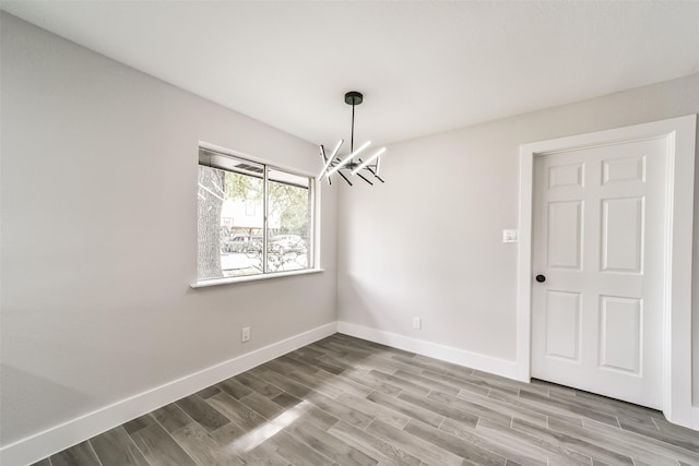 unfurnished dining area with hardwood / wood-style flooring and an inviting chandelier