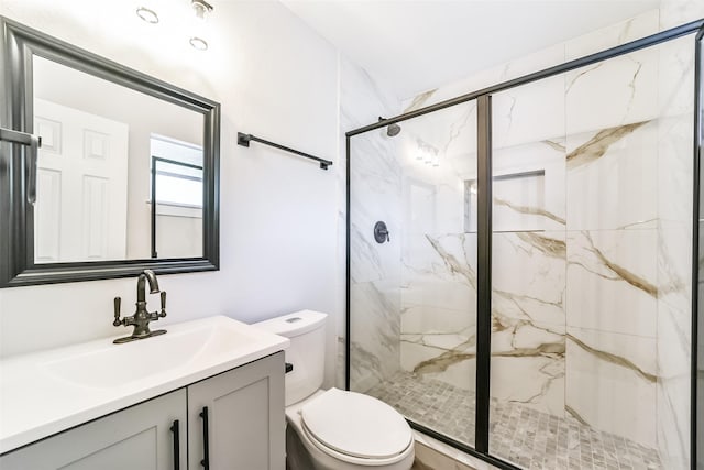 bathroom with a shower with door, vanity, and toilet