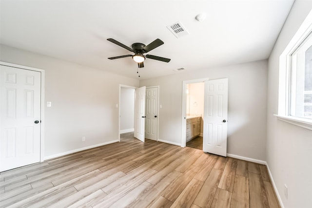 unfurnished bedroom with ensuite bath, light hardwood / wood-style flooring, and ceiling fan