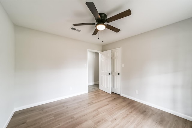 empty room with ceiling fan and light hardwood / wood-style flooring