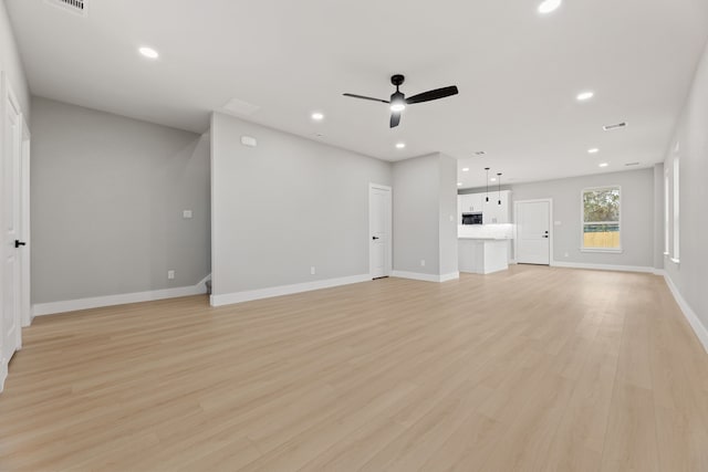 unfurnished living room with ceiling fan and light wood-type flooring