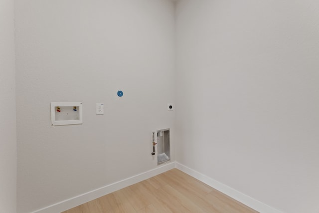 clothes washing area featuring hardwood / wood-style flooring, washer hookup, hookup for an electric dryer, and hookup for a gas dryer