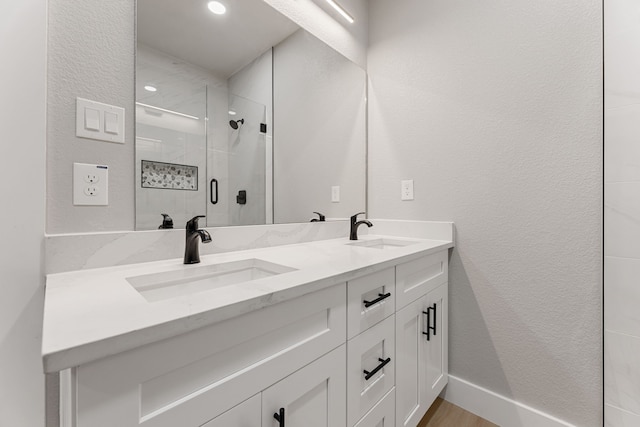 bathroom featuring walk in shower, vanity, and hardwood / wood-style flooring