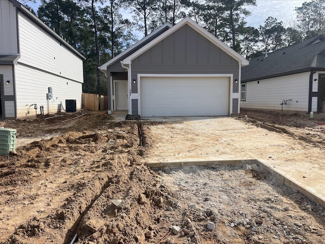 view of front of house with a garage, an outdoor structure, and central AC