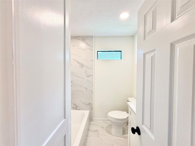 full bathroom featuring vanity, tiled shower / bath combo, toilet, and a textured ceiling