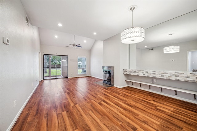 unfurnished living room featuring ceiling fan, a multi sided fireplace, wood-type flooring, and lofted ceiling