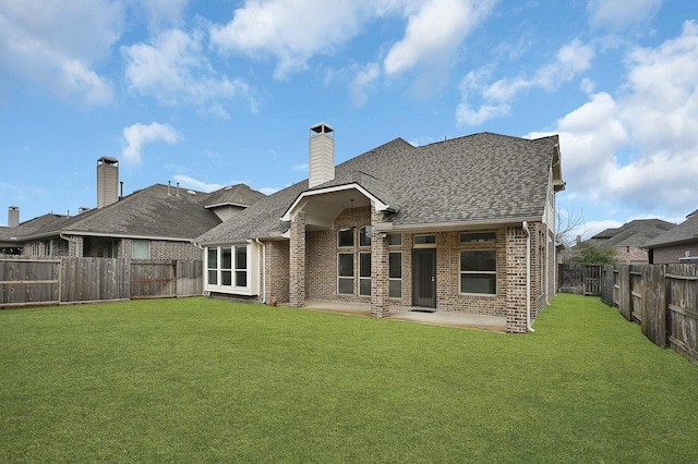 rear view of house featuring a yard and a patio area