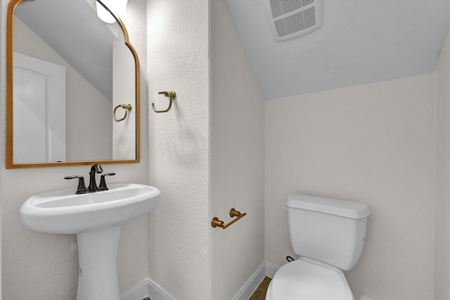 bathroom featuring lofted ceiling, sink, and toilet