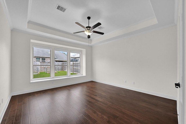 empty room with crown molding, ceiling fan, dark hardwood / wood-style flooring, and a tray ceiling