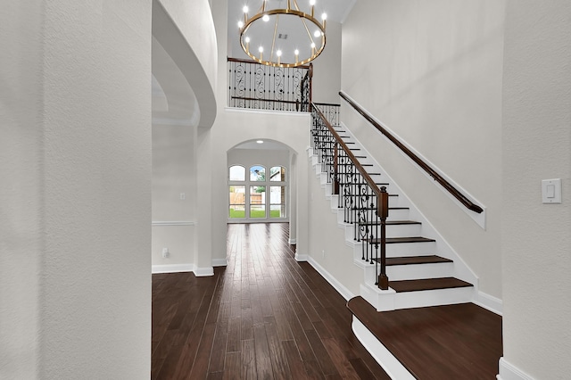 entryway featuring a high ceiling, dark wood-type flooring, and a notable chandelier