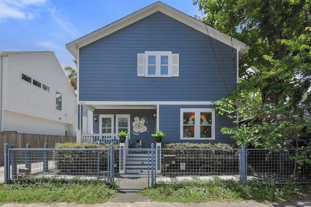 view of front of home featuring covered porch and a fenced front yard