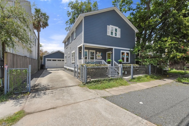 view of front facade with an outbuilding, a fenced front yard, covered porch, a garage, and a gate