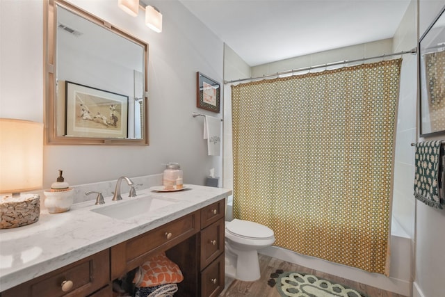 bathroom featuring toilet, visible vents, wood finished floors, and vanity