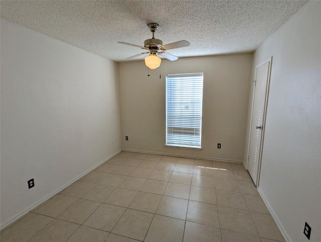 tiled spare room featuring a textured ceiling and ceiling fan