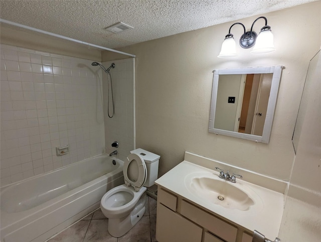 full bathroom featuring tiled shower / bath combo, vanity, tile patterned flooring, toilet, and a textured ceiling