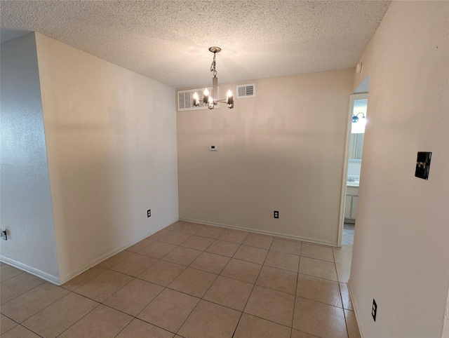 unfurnished dining area featuring light tile patterned floors, a notable chandelier, and a textured ceiling