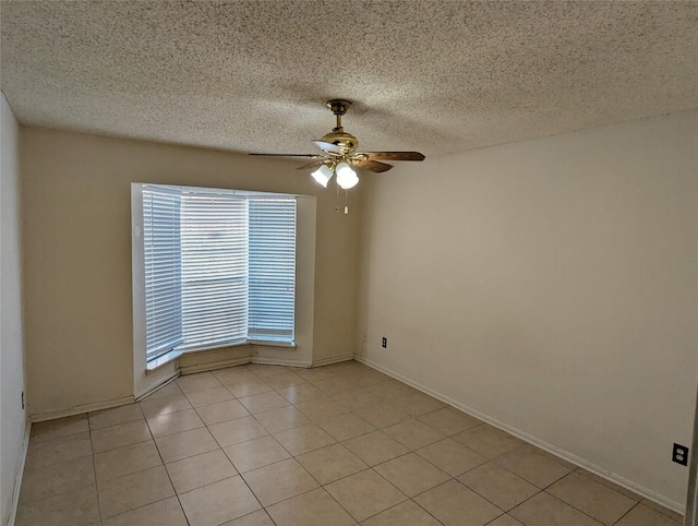 tiled spare room featuring a textured ceiling and ceiling fan