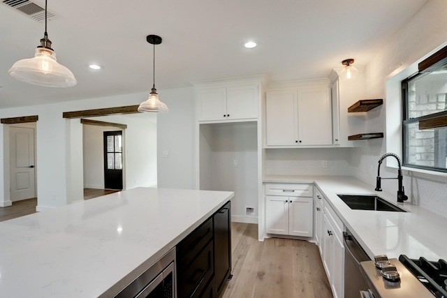 kitchen featuring pendant lighting, sink, white cabinetry, and light hardwood / wood-style floors