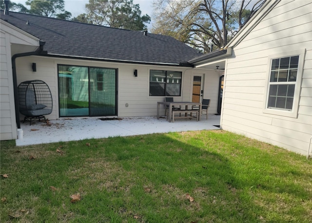 back of house with a lawn and a patio