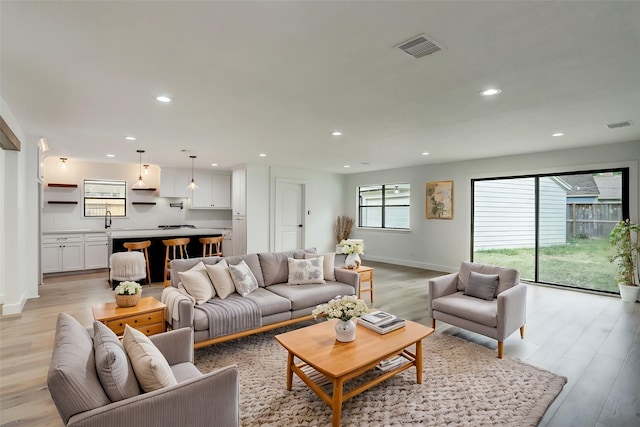 living room with sink and light hardwood / wood-style flooring