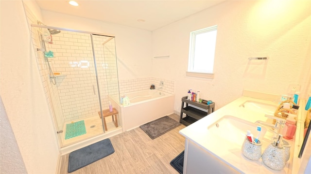 bathroom featuring vanity, hardwood / wood-style floors, and separate shower and tub