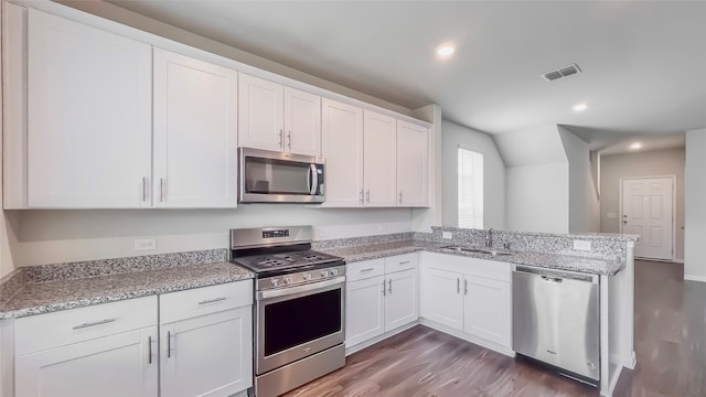 kitchen with light stone countertops, appliances with stainless steel finishes, sink, and white cabinets